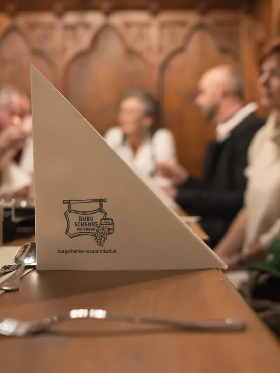 Festive dinner table at Burgschenke Mauterndorf with blurred guests in the background